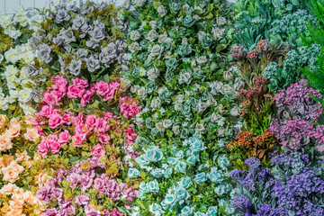 artificial blooming roses of orange, blue and pink color background