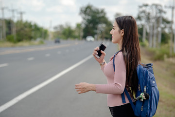 Travelers, women waiting for cars on the roadside,Journey travel concept.