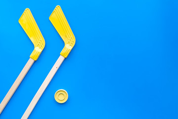 Ice hockey stick and puck on blue background top view space for text