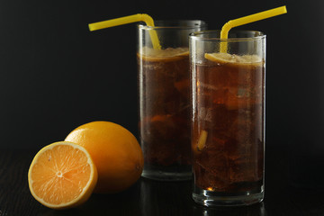 Glasses with cuba libre cocktail or cola with ice or cold tea with lemon