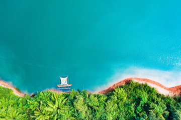 (View from above) Stunning aerial view of a a green coast of a tropical island with a traditional...