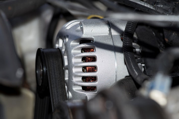 Ein Motor von einem Auto und Nahaufnahme der Lichtmaschine und Keilriemen
