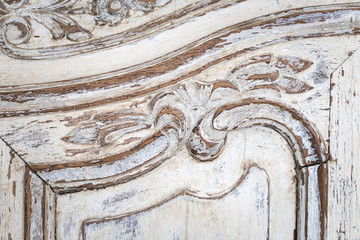 Vintage chest of drawers with carving white color with fading and metal handle. Close-up. Selective focus