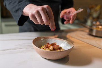 Young chef cook decorating dish in kitchen