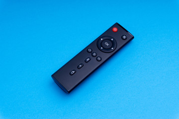 Remote control TV or radio isolated on blue background with selective focus and crop fragment