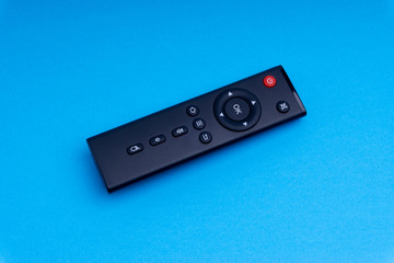 Remote control TV or radio isolated on blue background with selective focus and crop fragment