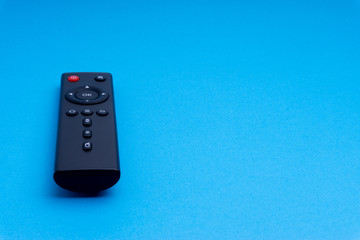 Remote control TV or radio isolated on blue background with selective focus and crop fragment