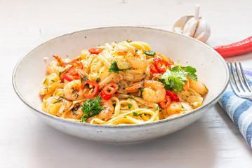 Linguine with shrimps on a rustic plate close-up - traditional Mediterranean pasta with seafood, Italian cuisine.
