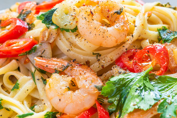 Linguine pasta with shrimps, parsley and chilli pepper close-up, macro. Traditional Mediterranean pasta with seafood, Italian cuisine.