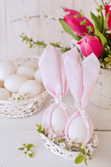 Fototapeta na wymiar Happy easter. Decor of Easter eggs in the form of Easter bunnies in small white baskets.