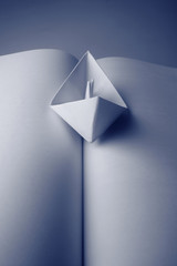 A paper boat in a open book