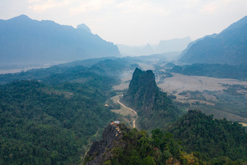 Fototapeta na wymiar (View from above) Stunning aerial view of a beautiful little hut on top of the Pha Ngeum Viewpoint reachable by climbing a limestone mountain. Vang Vieng, Laos.