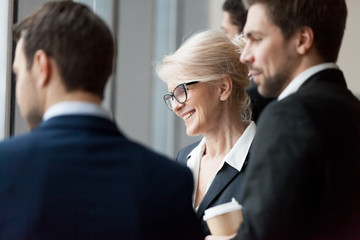Happy executive businesspeople looking through office window building future plans