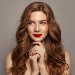 Smiling red haired woman portrait. Cute redhead girl with curly hair