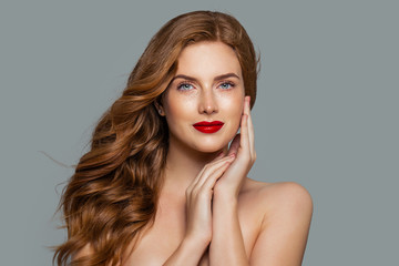 Pretty woman with ginger curly on blue background. Stylish redhead girl with curly hairstyle...