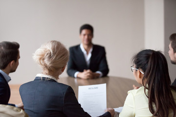 Rear view of hr listening to applicant at job interview