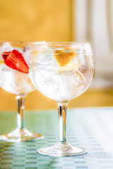 Dos Cocktails de gintonic de ginebra con tónica en ambiente cálido y fondo desenfocado