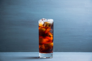 Cold cola beverage in glass with ice. Selective focus. Shallow depth of field.