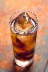 Cold cola beverage in glass with ice. Selective focus. Shallow depth of field.