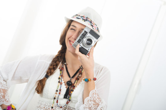 beautiful hippie woman with vintage camera and summer hat