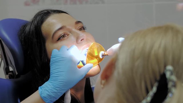 Dentist doing a dental treatment on a female patient.