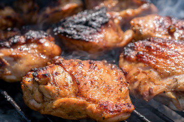 Grilled chicken thigh on the flaming grill