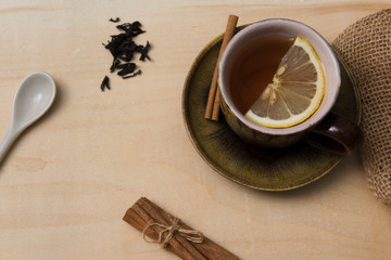 A cup of tea. Lemon, cinnamon sticks.
