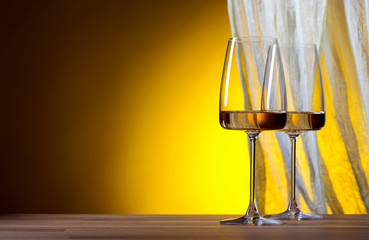 Glasses of wine on a yellow background.