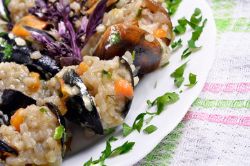 Risotto with mussels  in the plate on a wooden old table/paella/,selective focus