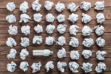 Ideological concept with wastepaper light bulb on wooden table