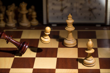 White's victory on the chessboard. The king fell.Strategy, victory, intelligence.The pawn attacks the king. Shot in motion. Flying figures.