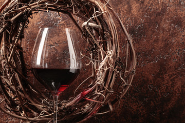 Vine wreath and glass of red wine.