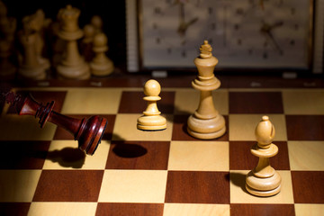 White's victory on the chessboard. The king fell.Strategy, victory, intelligence.The pawn attacks the king. Shot in motion. Flying figures.