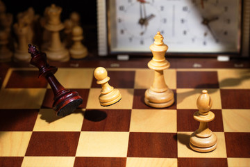 White's victory on the chessboard. The king fell.Strategy, victory, intelligence.The pawn attacks the king. Shot in motion. Flying figures.