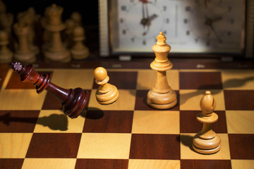 White's victory on the chessboard. The king fell.Strategy, victory, intelligence.The pawn attacks the king. Shot in motion. Flying figures.