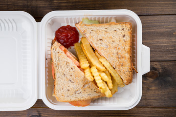 Sandwich with french fries packed in plastic box for lunch