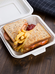 Sandwich with french fries packed in plastic box for lunch