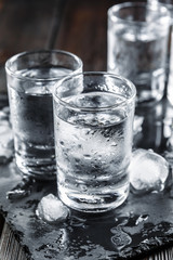 Vodka in shot glasses on rustic wood background