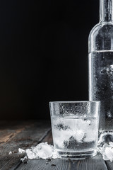 Vodka in shot glasses on rustic wood background