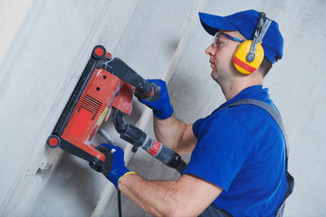 electrician at work. cutting concrete wall for cabling by diamond slitting machine