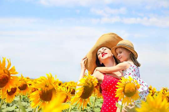 Mother and her little daughter in the sunflower field