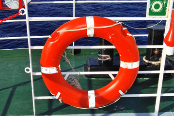 Red and white life belt hanged on a boat