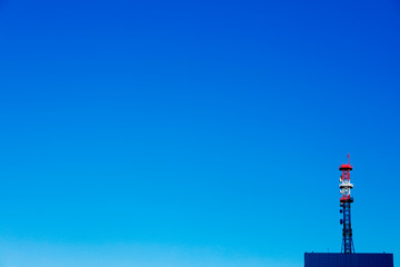 communication tower on the building with blue sky on background.