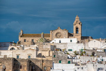 Obraz premium Panorama of The picturesque old town and Roman Catholic cathedral - Assumption of the Virgin Mary (Concattedrale di Santa Maria Assunta). The white city in Apulia on the hill - Ostuni , Puglia, Italy