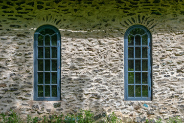 Old plastered building made from slag stone with two blue vaulted windows