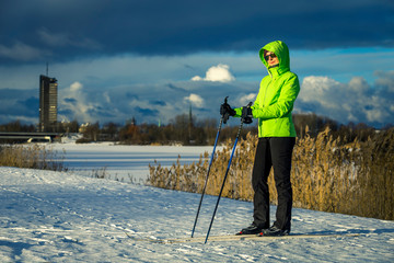 Woman doing classic nordic cross country skiing in park in Riga, Latvia