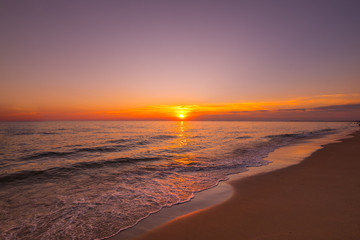 Vivid beautiful sunset and sunrise sky reflection on sea beach wave.