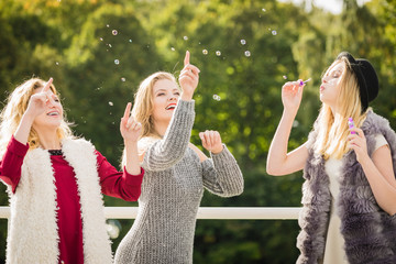 Women friends blowing soap bubbles.