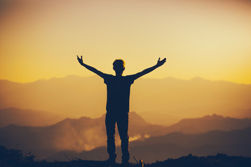 Fototapeta premium Man standing with lift hands for worshipping God at sunset background. christian silhouette concept.