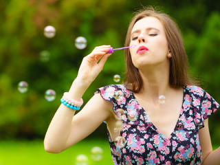 Woman blowing soap bubbles, having fun